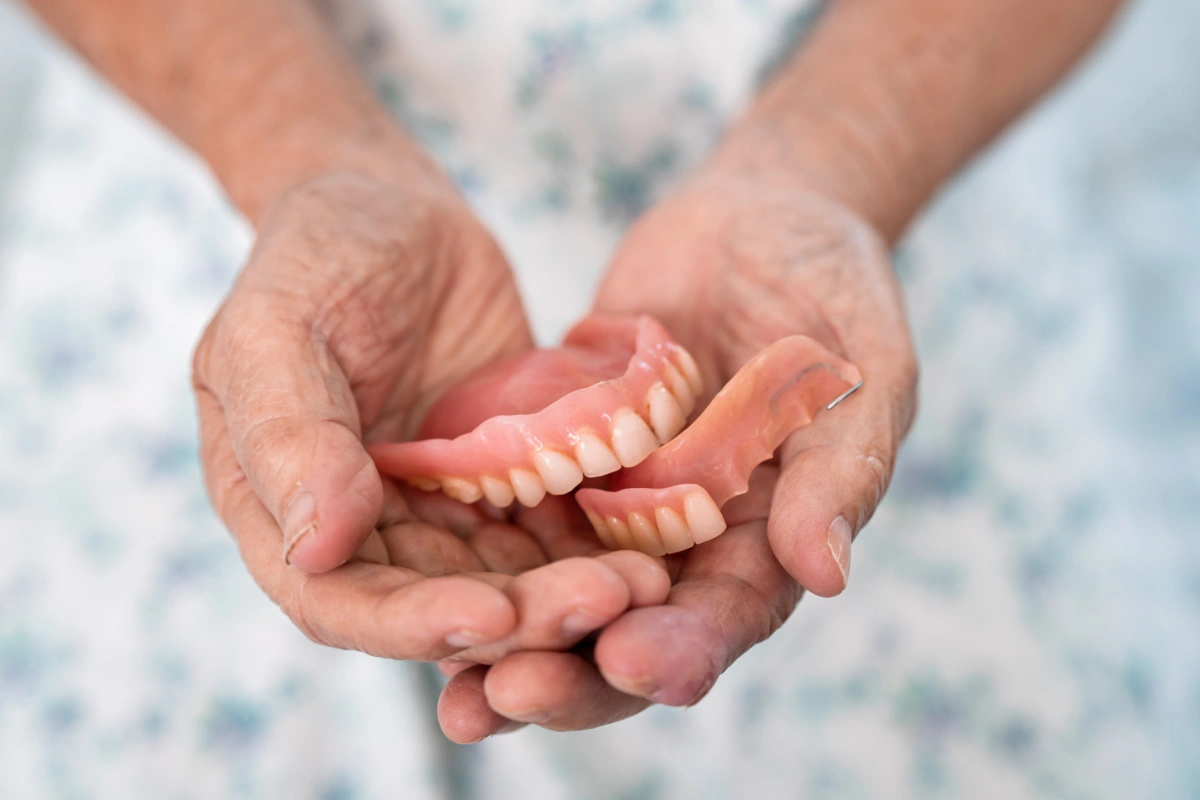 Adult hands cradling newborn baby's foot in tender moment