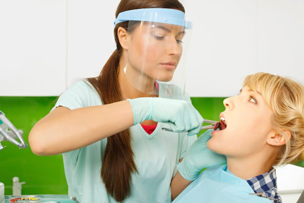 Dentist examining child patient's teeth during dental checkup in Winchester office.