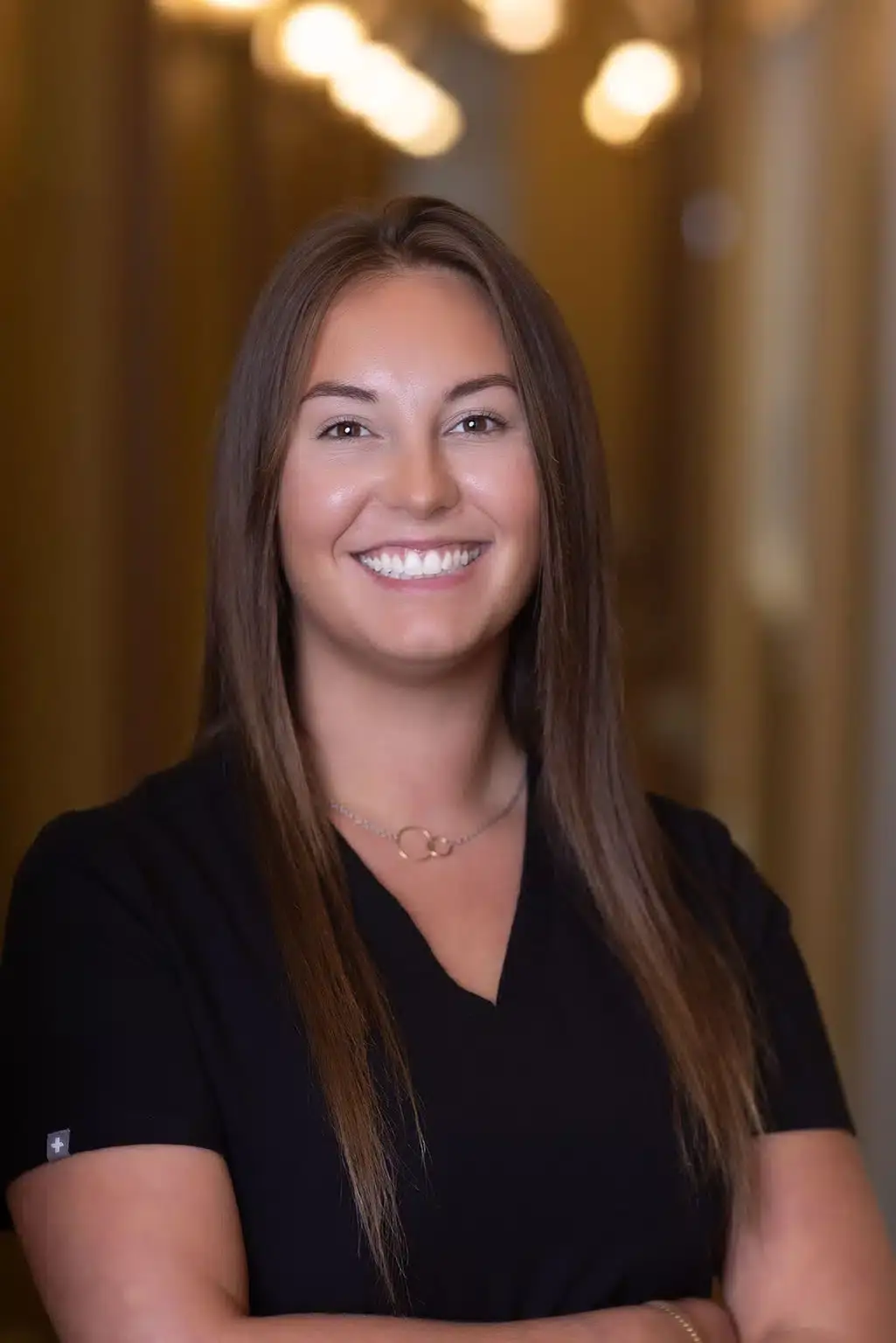 Team member smiling in professional black shirt at Winchester dental practice.