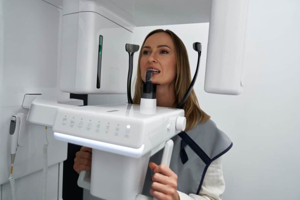 Female dental professional demonstrating intraoral camera usage for oral cancer screening examination.