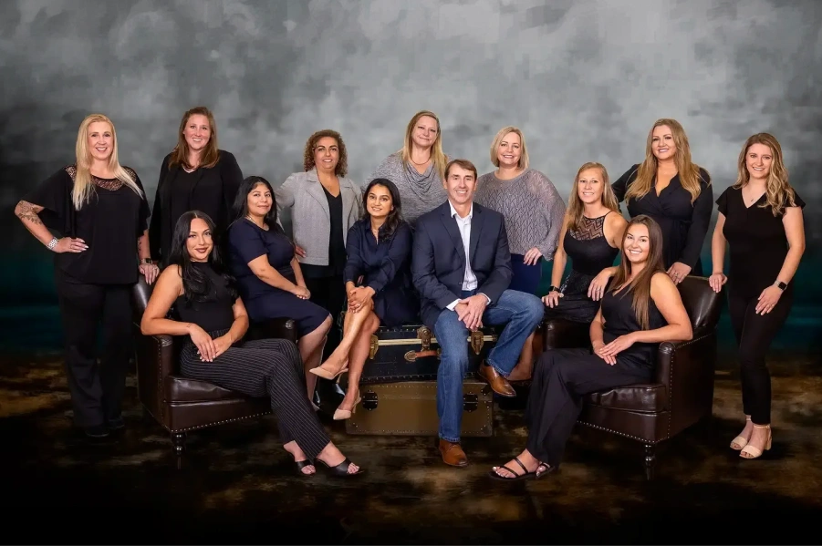 Dentists and staff of the dental practice gathered together indoors.